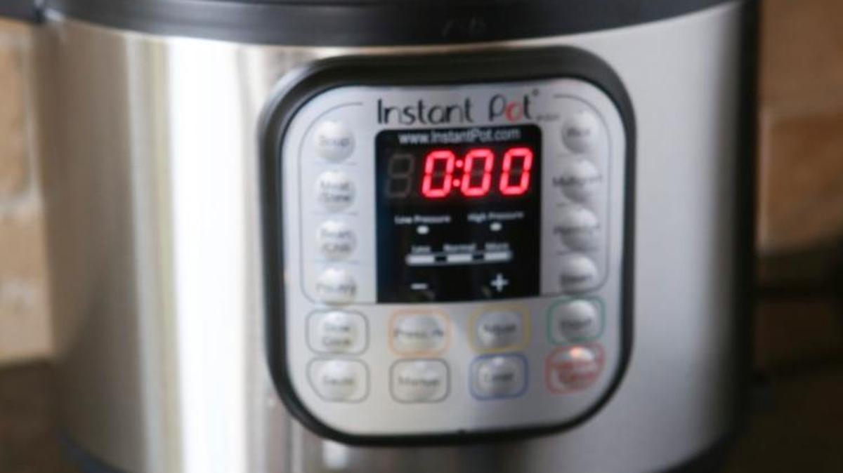 A bowl of green chili sits in front of the Instant Pot, an electric pressure cooker that is all the rage in kitchen appliances.