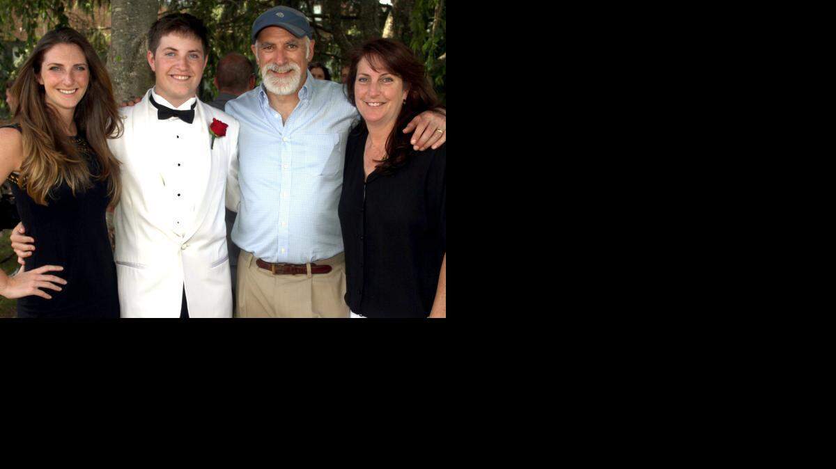 
In this June 28, 2014, photo, the Davies family, from left, Leah, Adam, Phil and Lauren, pose for a family photo after Adam’s high school graduation at Garden City High School in Garden City, N.Y. As a college sophomore in 2011, Leah Davies, then 19, had fallen ill from an out-of-control sinus infection. Because she was a legal adult when it came to care providers sharing health information with parents, her mom and dad were forced to the sidelines. (AP Photo/ courtesy of Kevin Williams)
