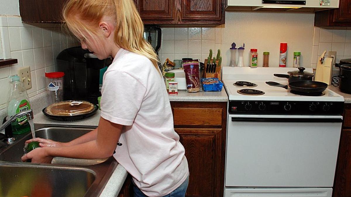 
Brooklynn Bucher washes vegetables as she and her father, Matt, prepare dinner. They participate in the Daddy and Me cooking and nutrition program at the Extension Center.
