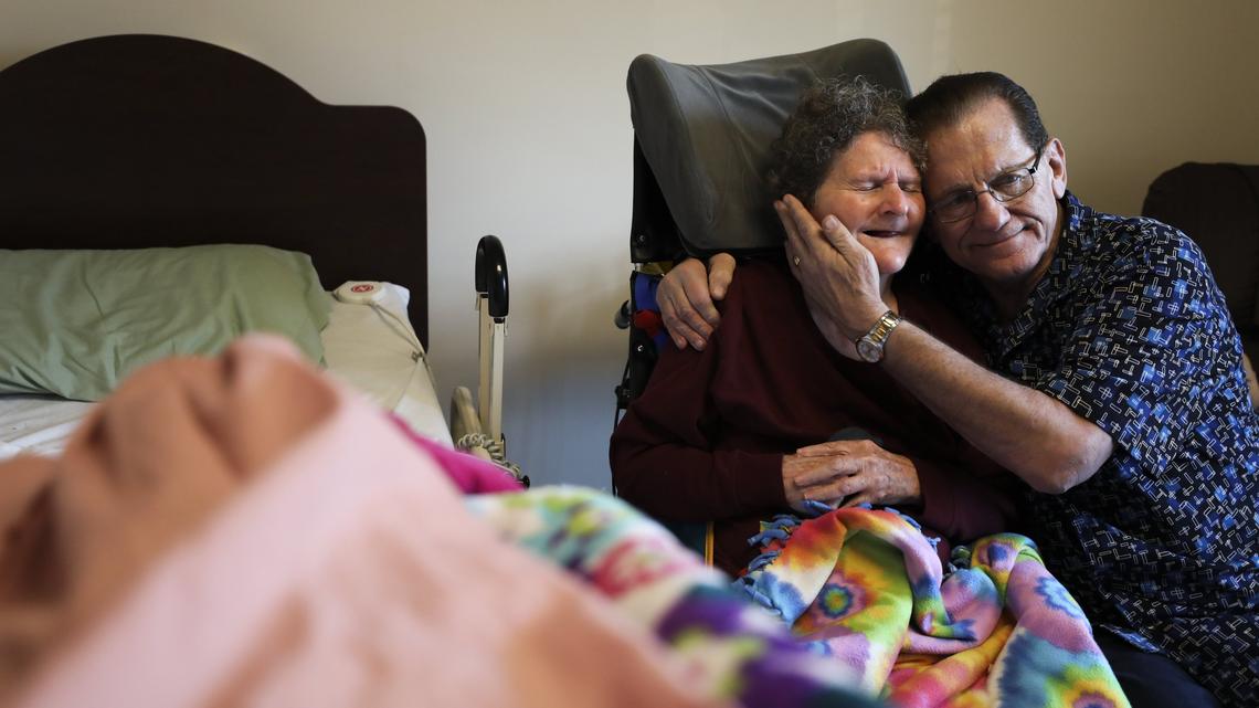 Gary Blevins holds his wife, Carol, as they share a moment while watching TV in her room at Via Christi Village. Gary began noticing signs of dementia about 11 years ago. Carol has been in a memory care unit since 2011.