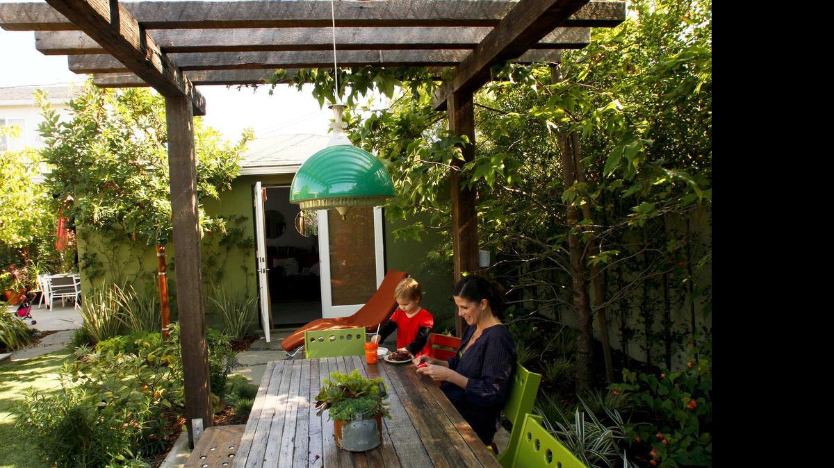 
An arbor provides a ceiling, and a wall and trees provide the walls in this garden room.
