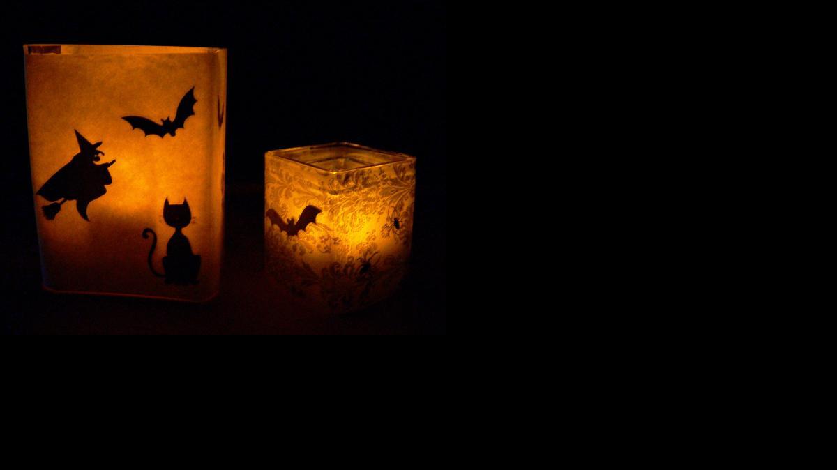 
Attach black stickers to vellum or the waxy side of freezer paper and wrap around a clear glass vase, adhering with double-sided tape. Insert battery-operated votives.
