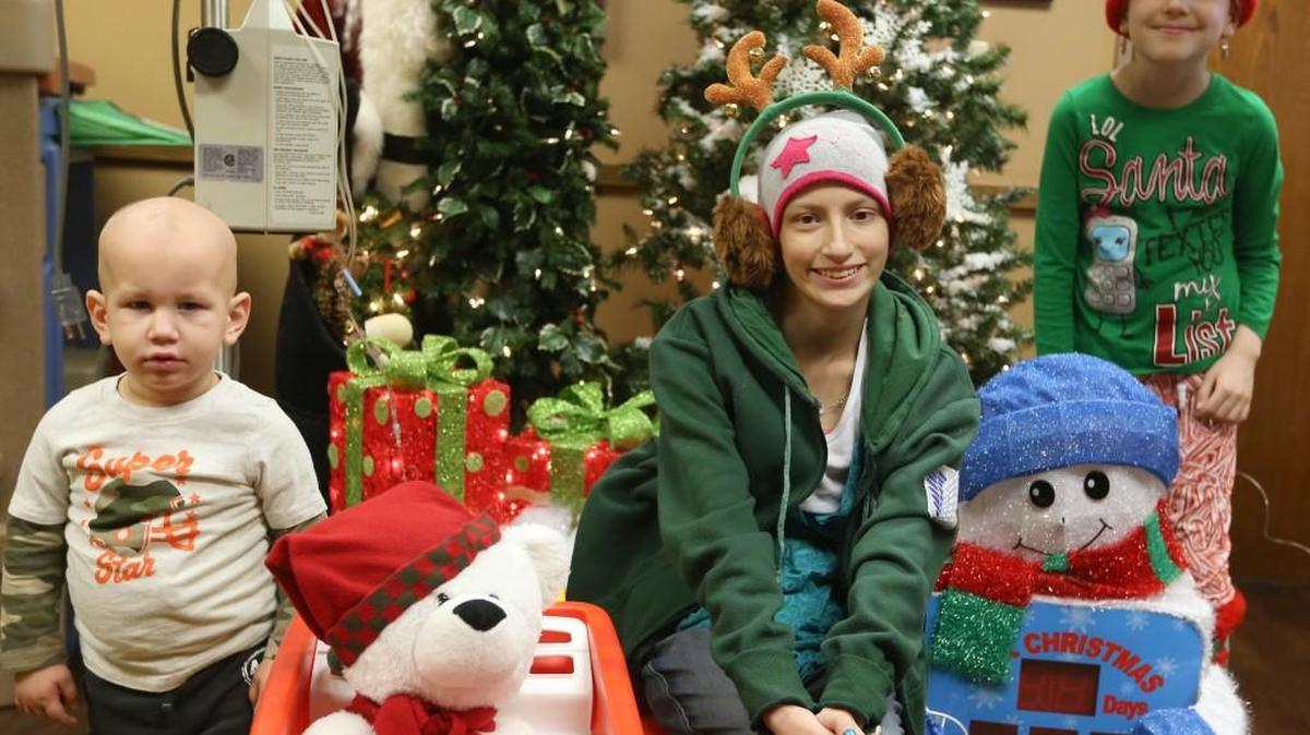 Christmas decorations are put up in David Rosen’s pediatric oncology office to cheer patients including Grayson Westeman, Destiny Garcia and Brooklyn Cowsill.