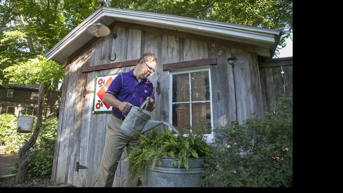 
“I like old stuff,” Bob Neier says, watering a fern in front of a shed whose parts come from the farm he grew up on, the door decorated with a barn quilt he painted.
