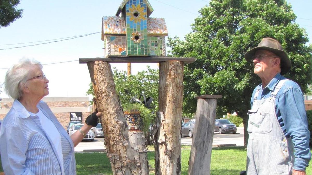Susan Koehn and Milton Claassen, board members of Carriage Factory Art Gallery in Newton, check out a new mosaic birdhouse made by Mary Lee McDonald in the gallery's Krehbiel Park. The park will be part of the Newton garden tour this weekend.