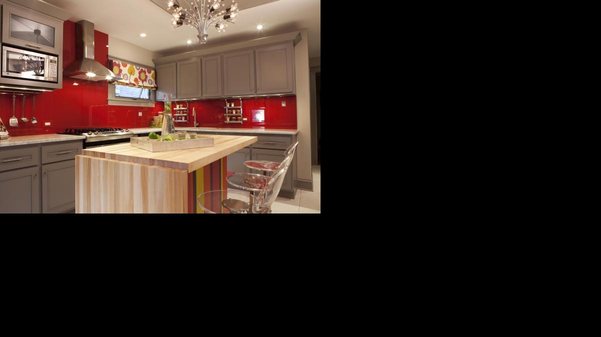 
Meg Caswell, host of HGTV’s “Great Rooms,” painted the walls of this kitchen red then added a clear glass cover to create a chic, vibrant backsplash.
