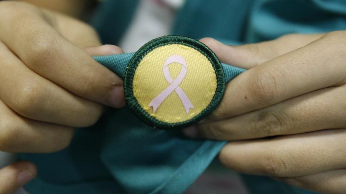 A breast cancer badge earned by a Girl Scout.