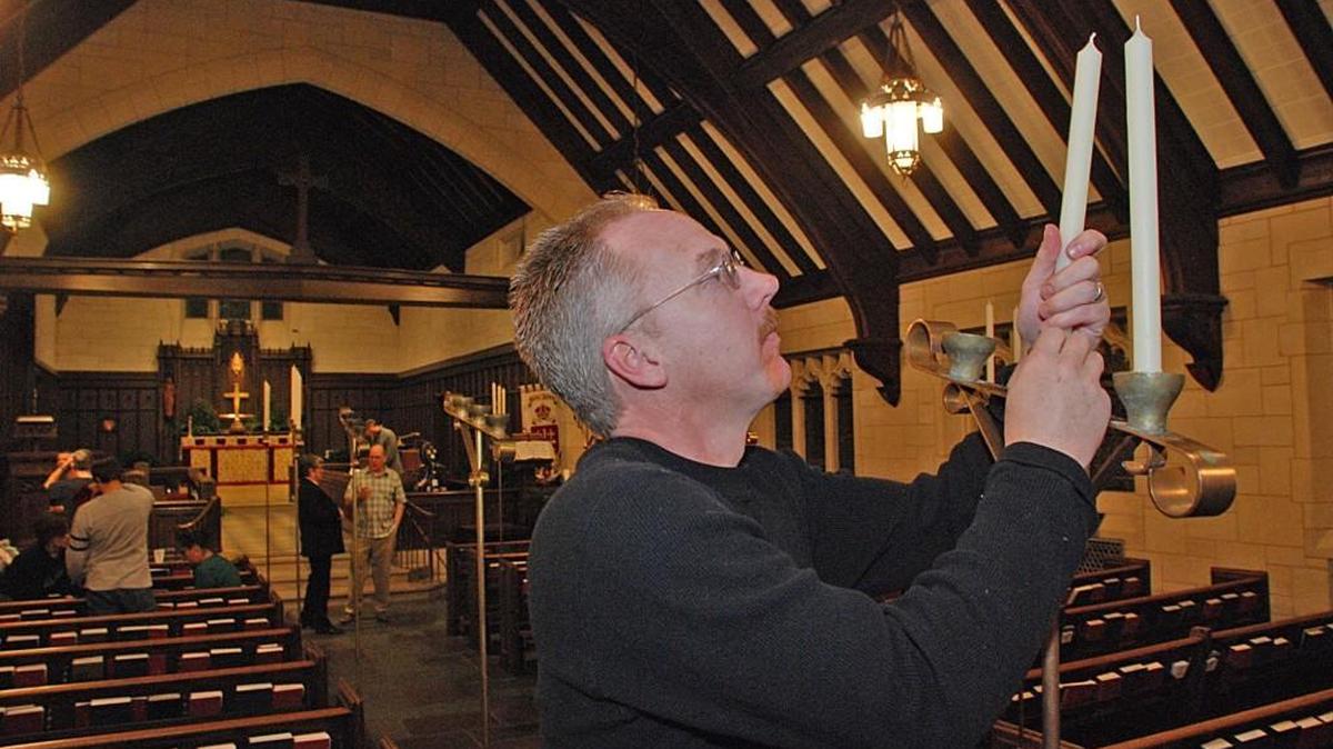 Matt Carroll places candles in the sanctuary Monday at St. James Episcopal Church during the Greening of the Church event.
