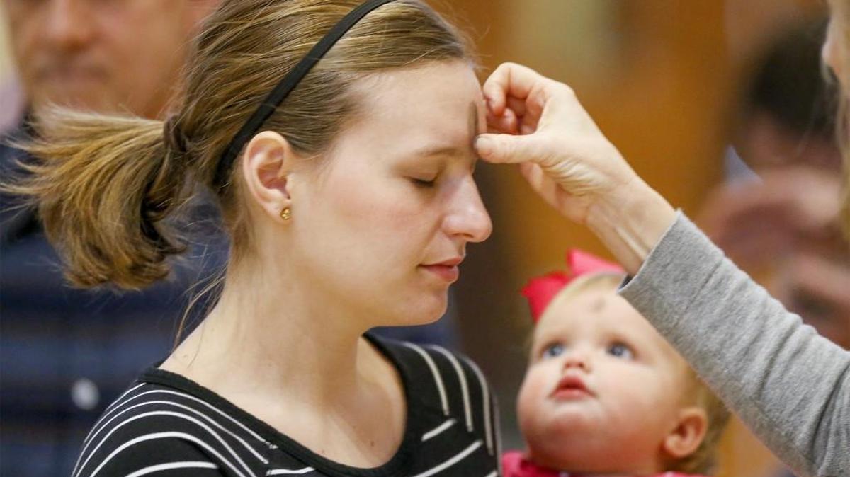Christine Umbehr and her daughter Leah receive ashes on Ash Wednesday in 2016. For the first time, Table of Hope Metropolitan Community Church in Wichita plans to offer its Ash Wednesday rites at the curb.