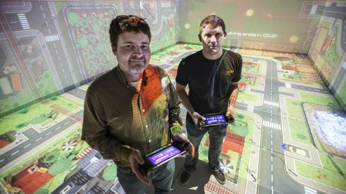 Owner and founder Kent Johnson, left, and president Jake Williams at Fireshark Gaming, a relatively new company that developed an immersive game-playing room-size technology that people play in a retail location. (Dec. 9 , 2015)
