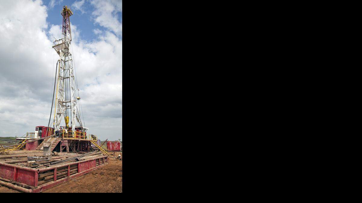 Oilfield workers with Bramwell Petroleum set up a drilling derrick for an oil well near Spivey, Kan.