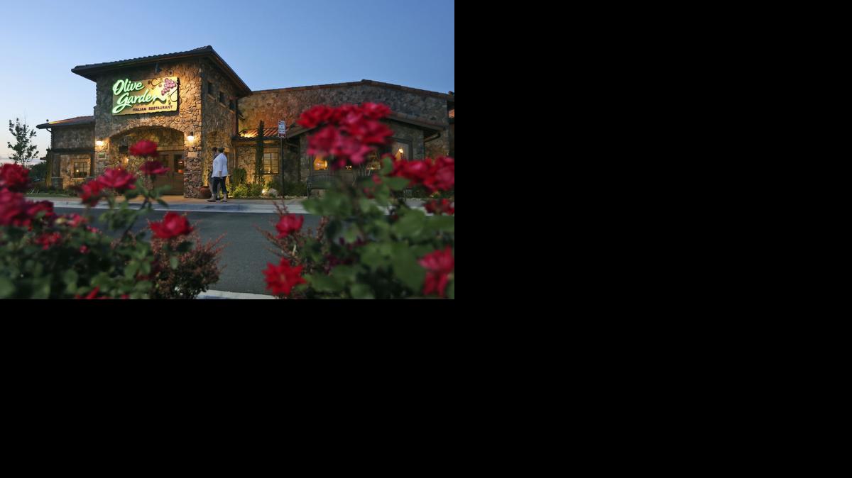 
In this May 2014 photo, patrons enter an Olive Garden Restaurant in Short Pump, Va. Olive Garden is hurting itself by piling on too many breadsticks, according to an investor that's disputing how the restaurant chain is run. 

