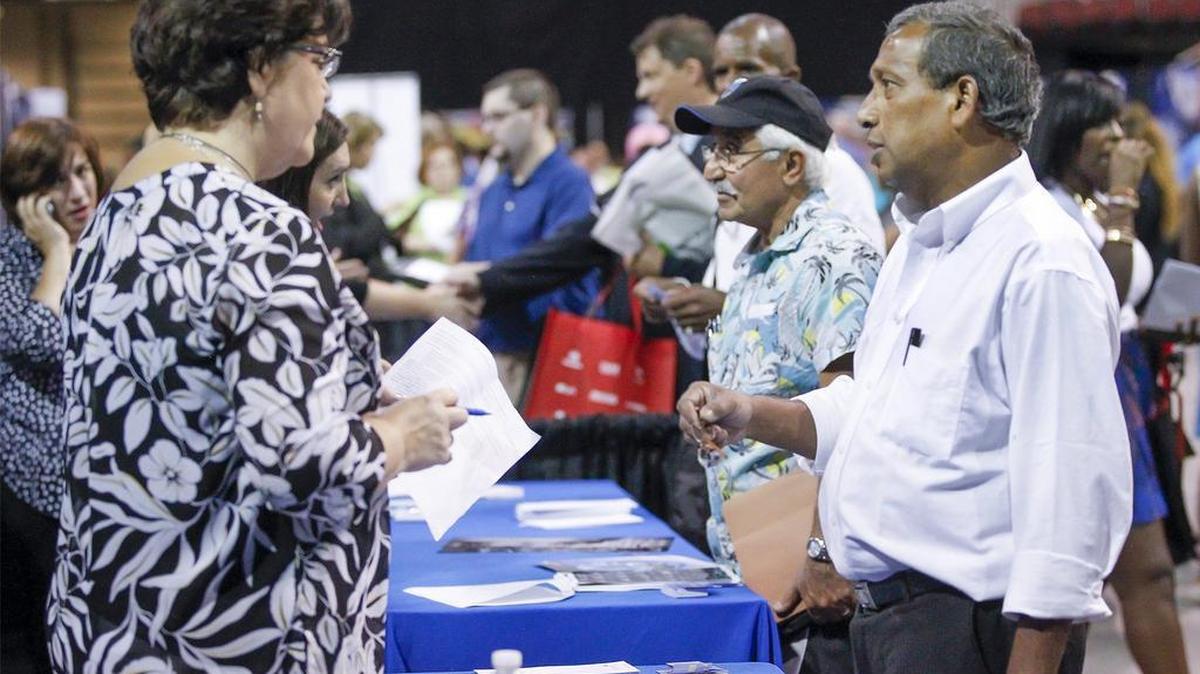 
Hementa Das, right, talks with a representative from Spirit AeroSystems at a job fair in Intrust Bank Arena. (Sept. 4, 2014)
