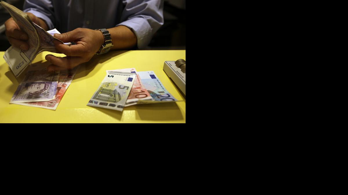 
An employee counts British pounds and Euro notes at a currency exchange office in downtown Rome Tuesday. Economists have plenty of quibbles, but many agree that the Federal Reserve accomplished the bulk of its goals with its bond-buying program, known as quantitative easing, or QE. The dollar has actually held up against most major currencies, as the euro and Japanese yen have slumped. 
