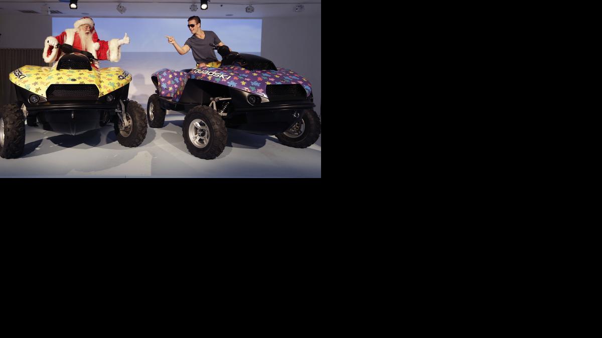 
Brady Smith, as Santa Claus, left, and David Miller show off the “His and Hers” 2014 Vilebrequin Quadskis during the unveiling of the Neiman Marcus Christmas Book Tuesday in Dallas. According to its maker, the “jet ski meets ATV “converts from a water cruiser to a land vehicle in under five seconds and costs $50,000 – each.
