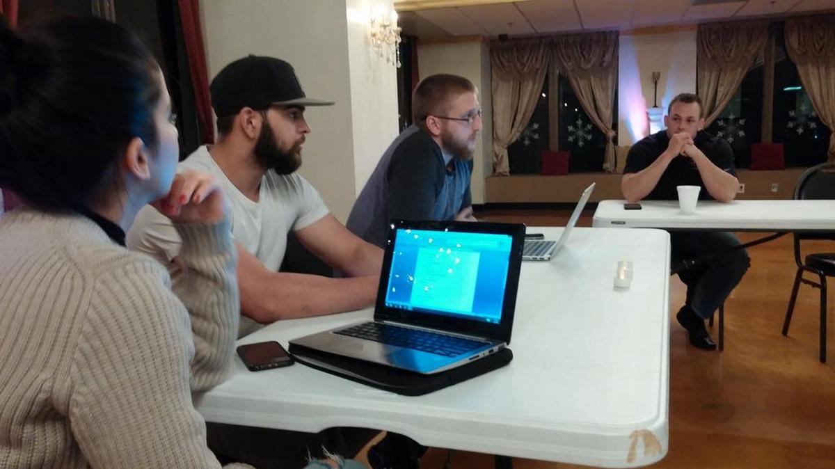 Hana Alsoudi and Zach Barakeh, left, listen to Tyler Engle speak, while Jason Lane, right, listens.
