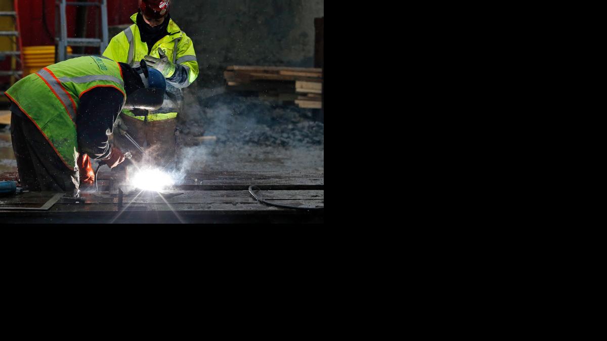 
Workers weld at a commercial construction site in Boston earlier this month. The U.S. economy slowed in the final three months of 2014 as a big burst in consumer spending was offset by weakness in other areas, according to the Commerce Department.
