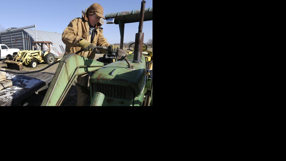 
Cattle rancher Randy Cree adds fuel to a tractor at his farm near Big Springs, Kan. Cree has not been able to afford to fill the fuel tanks at his farm, but with prices below $2.00 he plans to fill his two 300-gallon and one 200-gallon tanks.
