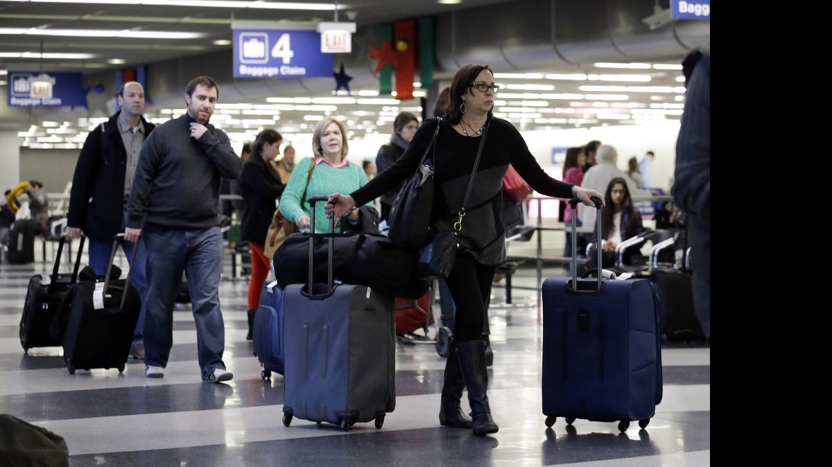 
Travelers walk near a baggage claim area at O’Hare International airport in Chicago in 2013. Fees on bags and for other things are becoming a bigger and bigger piece of the revenue pie for airlines.
