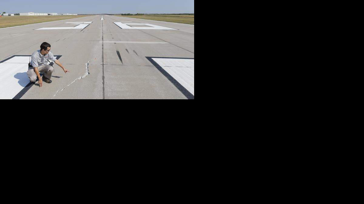 
Michael Piccone, airport operations officer with the Wichita Airport Authority, points out cracks in the runway at Jabara Airport that were caused when Boeing's 747 Dreamlifter landed there several months ago. Repairing the runway is one of several projects in the works at Jabara Airport. They are redoing the entrance to the airport and will renovate some of the existing T-hangars and add 13 new hangars.
