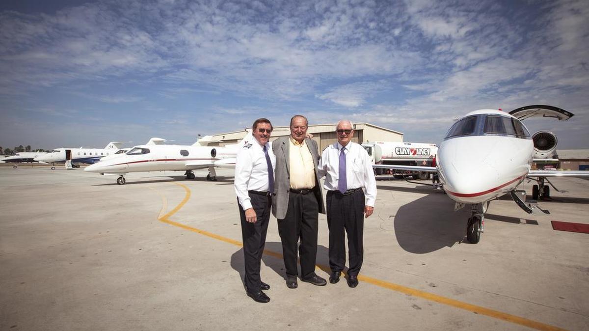 Bombardier Business Aircraft demonstration pilots Jeff Triphahn, left, and Ed Hillis pose with Clay Lacy, center, and their Learjet 75 at Van Nuys Airport in Los Angeles.
