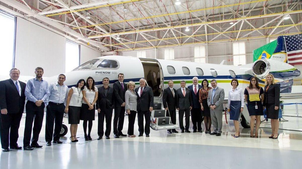 Officials from Embraer and Executive AirShare pose for a photo at a delivery ceremony Thursday in Brazil with the company’s newest Phenom 300 business jet.