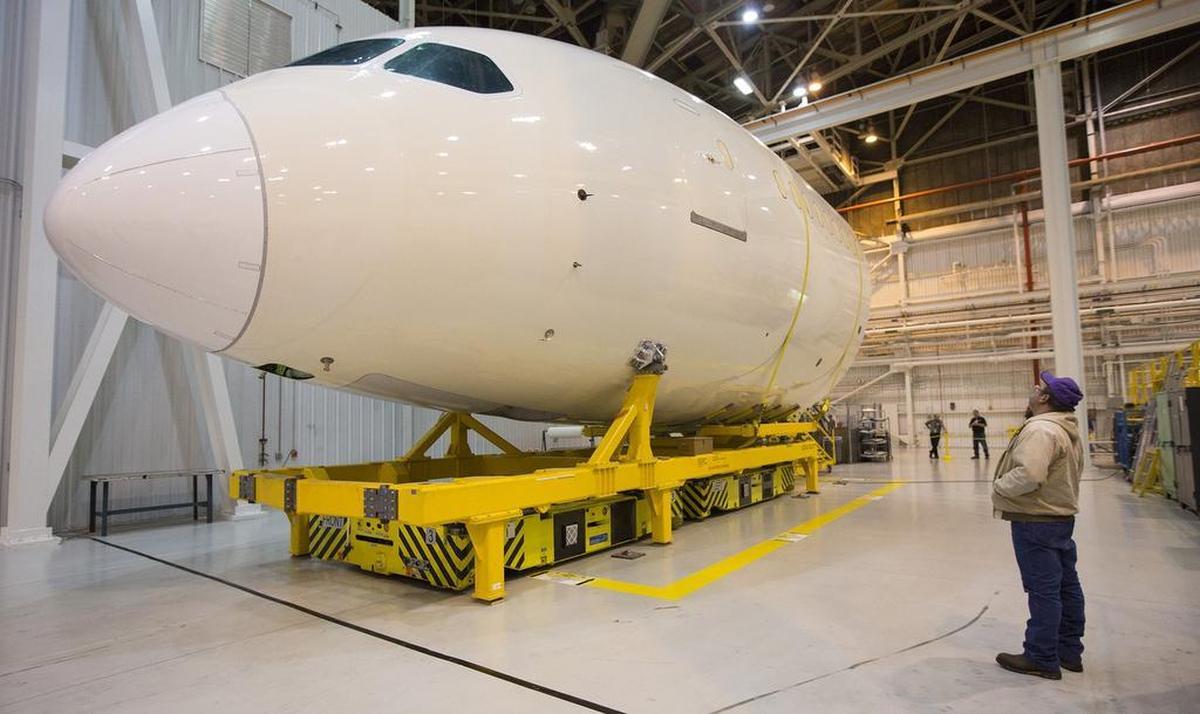 A Spirit AeroSystems employee looks at a Boeing 787 forward fuselage in Wichita. (Dec. 18, 2012)