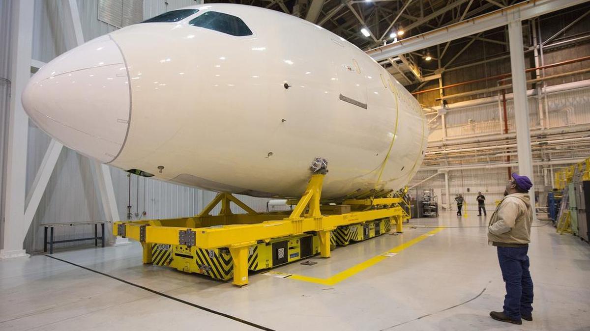 A Spirit AeroSystems employee looks at a Boeing 787 forward fuselage in Wichita. (Dec. 18, 2012)