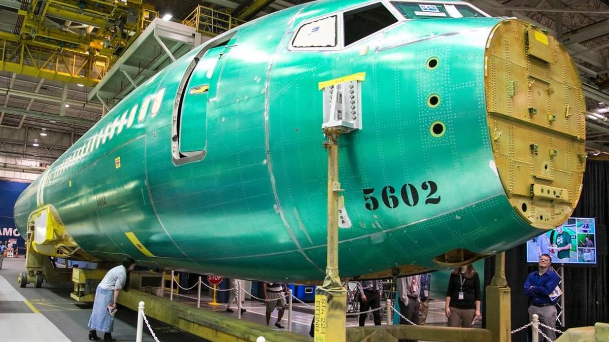 Spirit AeroSystems employees look over the first completed fuselage of the 737 MAX. GKN in Wellington manufactures 737 parts for Spirit, including the passenger cabin windows.