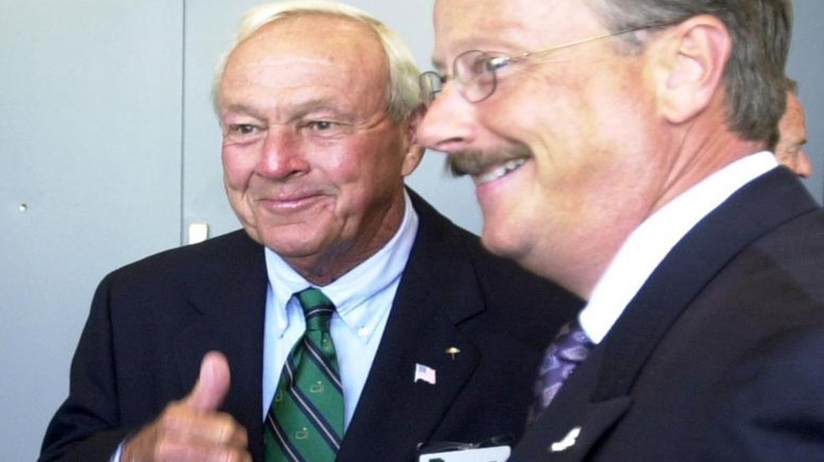 Golf legend Arnold Palmer, left, gives a thumbs-up to a passerby at the National Business Aviation Association convention in 2005. At right is former Cessna CEO Jack Pelton.
