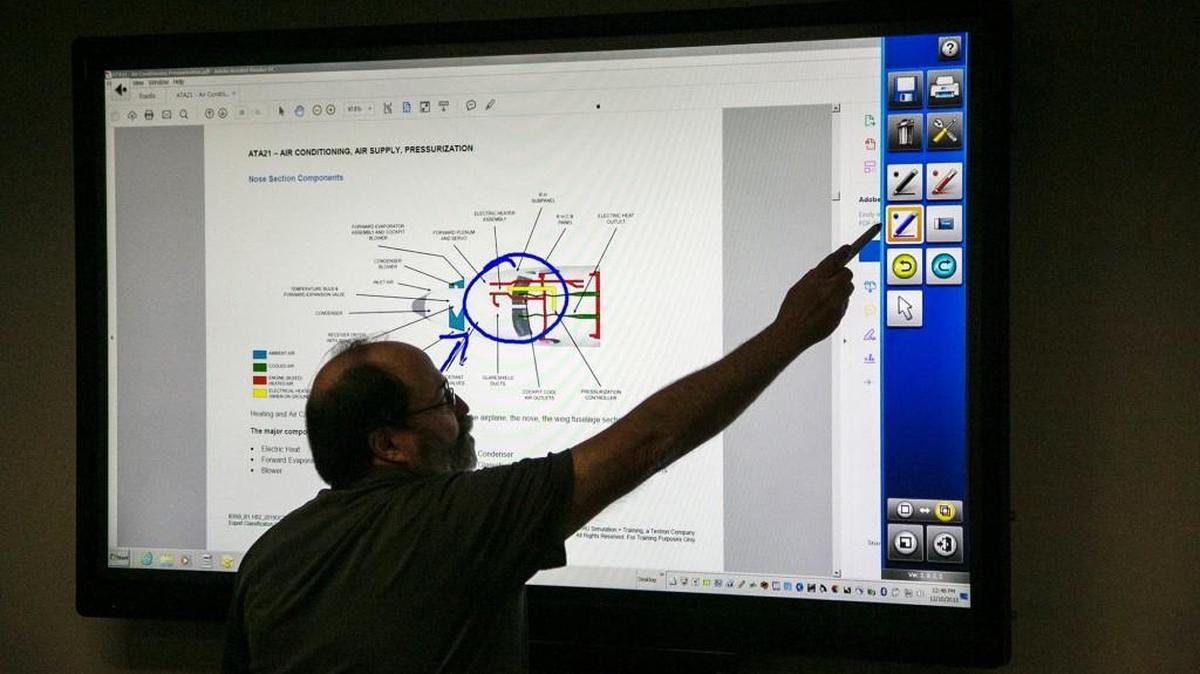 Mike Ward, avionics training manager and instructor, draws on a flat-screen monitor at Tru Simulation Plus Training’s Wichita Aviation Maintenance Training Academy on the Textron Aviation West Campus. Boeing has selected the Textron-owned firm to provide it with simulator suites for its new 777X wide-body jetliner. (Dec. 10, 2015)