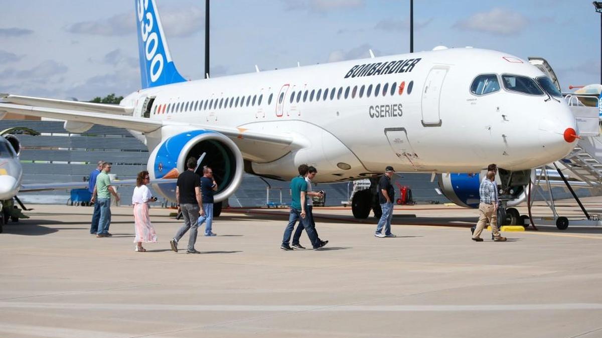 Employees and visitors to Bombardier Learjet in Wichita, walk by a Bombardier CS300 Friday morning as the plane sat on static display at Learjet.