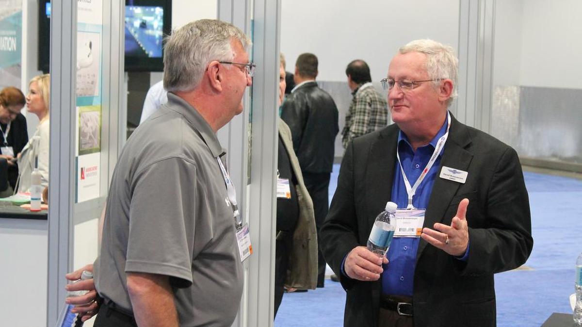 D.J. Dombrowski of Rexnord Aerospace in Illinois, left, talks with David Bossemeyer of the Greater Wichita Economic Development Coalition’s Wichita booth on Wednesday at the National Business Aviation Association Convention in Las Vegas.
