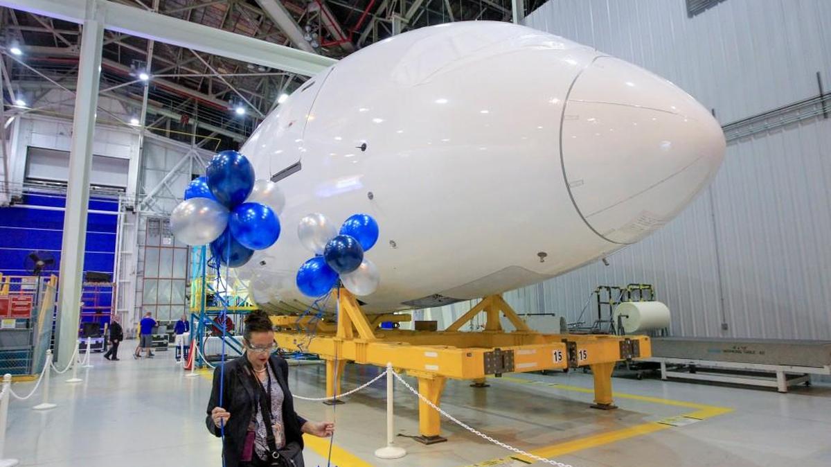 A Spirit AeroSystems employee walks past a Boeing 787 forward fuselage manufactured by the Wichita company following a celebration of the 500th 787 delivery last October. Demand for widebody jets like the 787 has slumped. (Oct. 11, 2016)