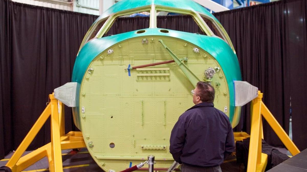 A Spirit AeroSystems employee looks at the 1,000th Boeing 777 forward fuselage section Spirit manufactured during a ceremony in 2011.