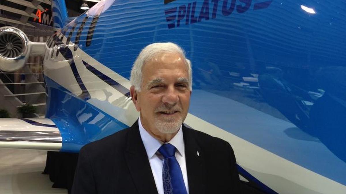 KCAC Aviation’s Angelo Fiataruolo stands next to Pilatus’ PC-24 business jet mockup at the 2014 National Business Aviation Association Convention.