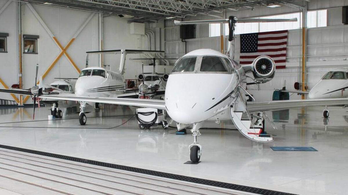 A Beechcraft King Air 250, left, and a Embraer Phenom 300 light business jet, both owned by Executive AirShare, sit inside a hangar at the company’s base at the Kansas City Downtown Airport.