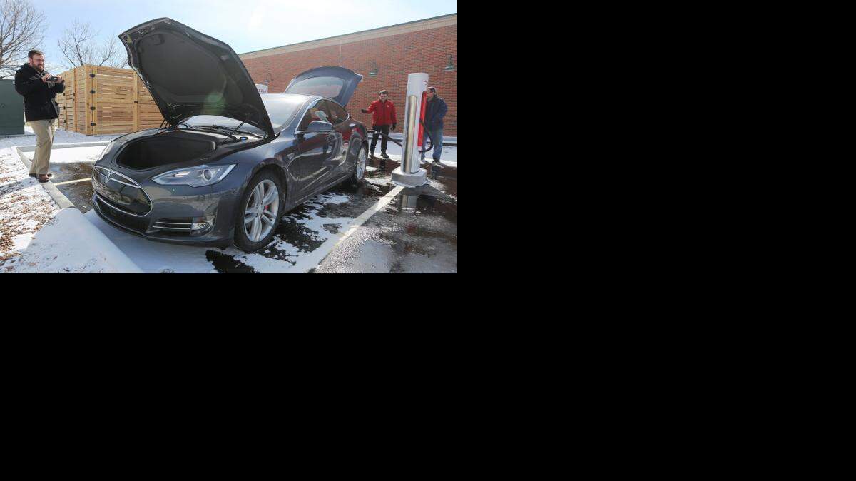 
Ryan Seitz photographs a Tesla Model S P85D on display next to the Applebee’s at 47th and Broadway. The all-electric cars have extra storage space under their hoods instead of engines. 
