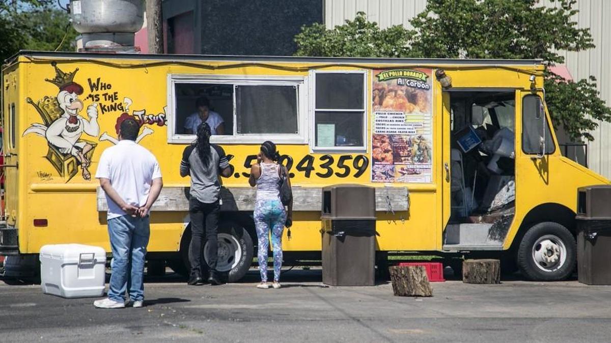 Customers line up at the El Pollo Dorado chicken truck on 21st Street between Main and Waco, where the business also is remodeling a building to open a restaurant.