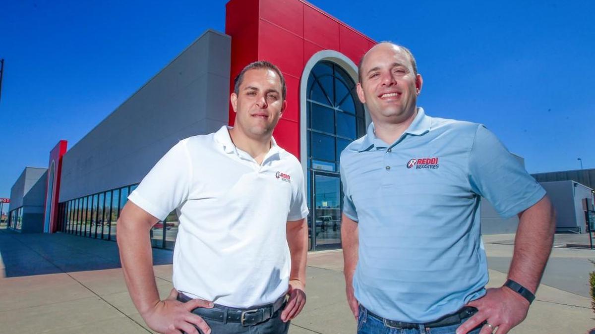 Zack, left, and Tommy Steven stand in front of their Reddi Industries, Overhead Door and Aero Fence headquarters on East Kellogg where a Davis-Moore dealership used to be.
