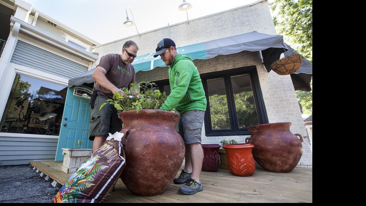 
Owner Luke Snow, left, and co-manager and designer Sol Arie put flowers in a planter in front of FarmShop, a landscaping and gardening company that is going to open a produce stand and retail store next to R Coffeehouse in Riverside. (May 21, 2015) 

