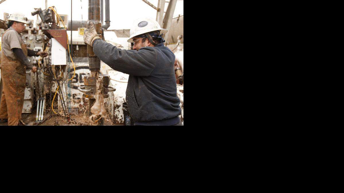 
Deckhands on an oil rig operated by SandRidge Energy change out a drill pipe on their rig in February 2012. Now SandRidge, like many oil companies, is reducing its drilling plans because of the steep drop in oil prices.

