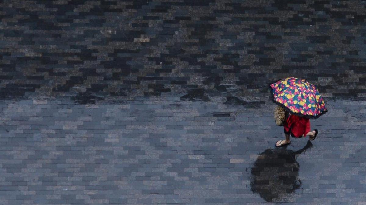 
A woman walks through One City Plaza in downtown Greenville, S.C., as rain and winds pounded the Upstate on Saturday. (Oct. 3, 2015)
