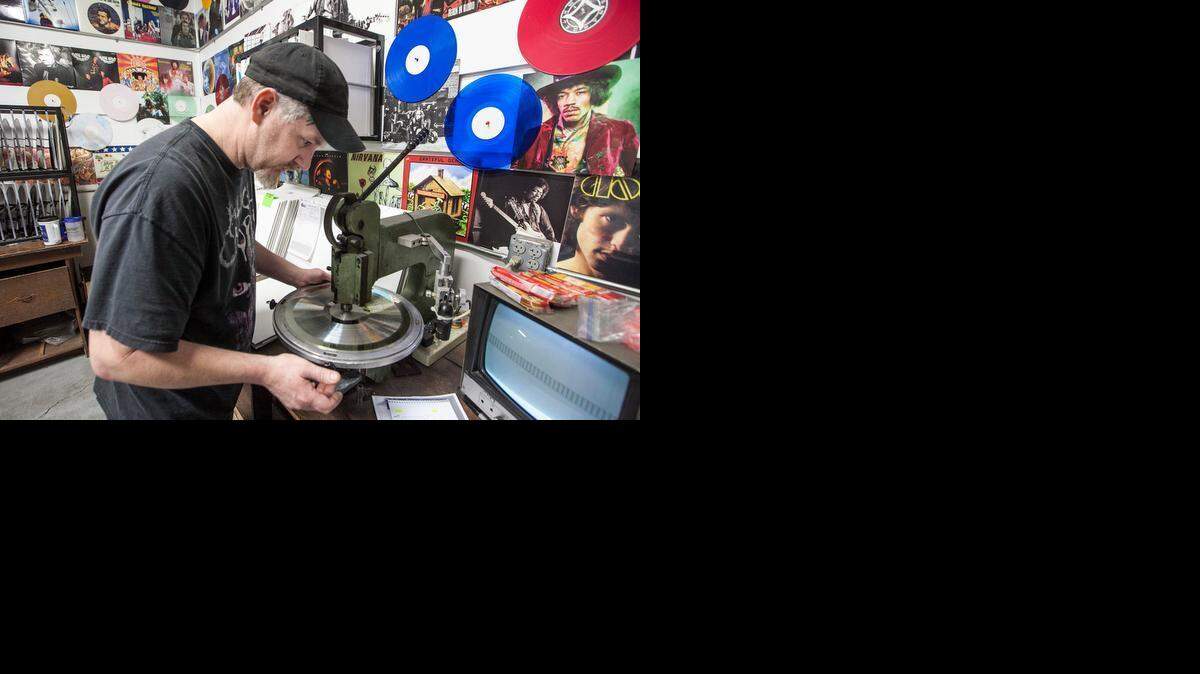 
Stan Bishop centers a nickel stamper used to press vinyl records in December. Acoustic Sounds, located in Salina, and its several subsidiaries employ 90 people and now plans to grow more as it adds machinery.
