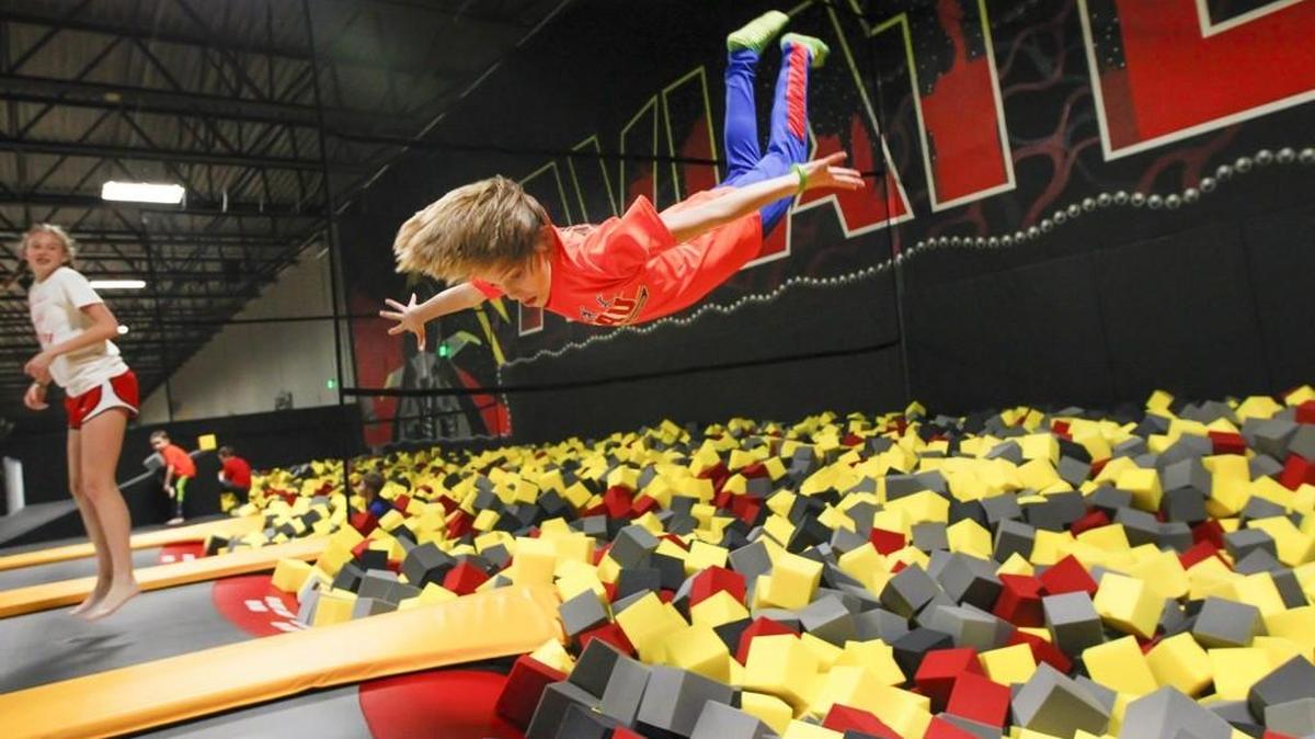 An 11-year-old jumps from a trampoline into a pit of foam blocks while playing at Wichita Sports Forum.