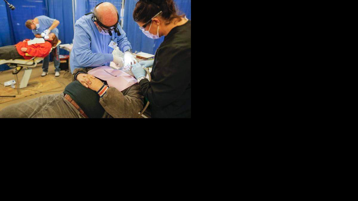 A patient has eight teeth extracted by dentist Rusty Coad and dental assistant Linda Fowler at the Kansas Mission of Mercy free dental clinic inside the Kansas Coliseum Pavilions in 2013. This year’s event is July 23-24 at Century II.
