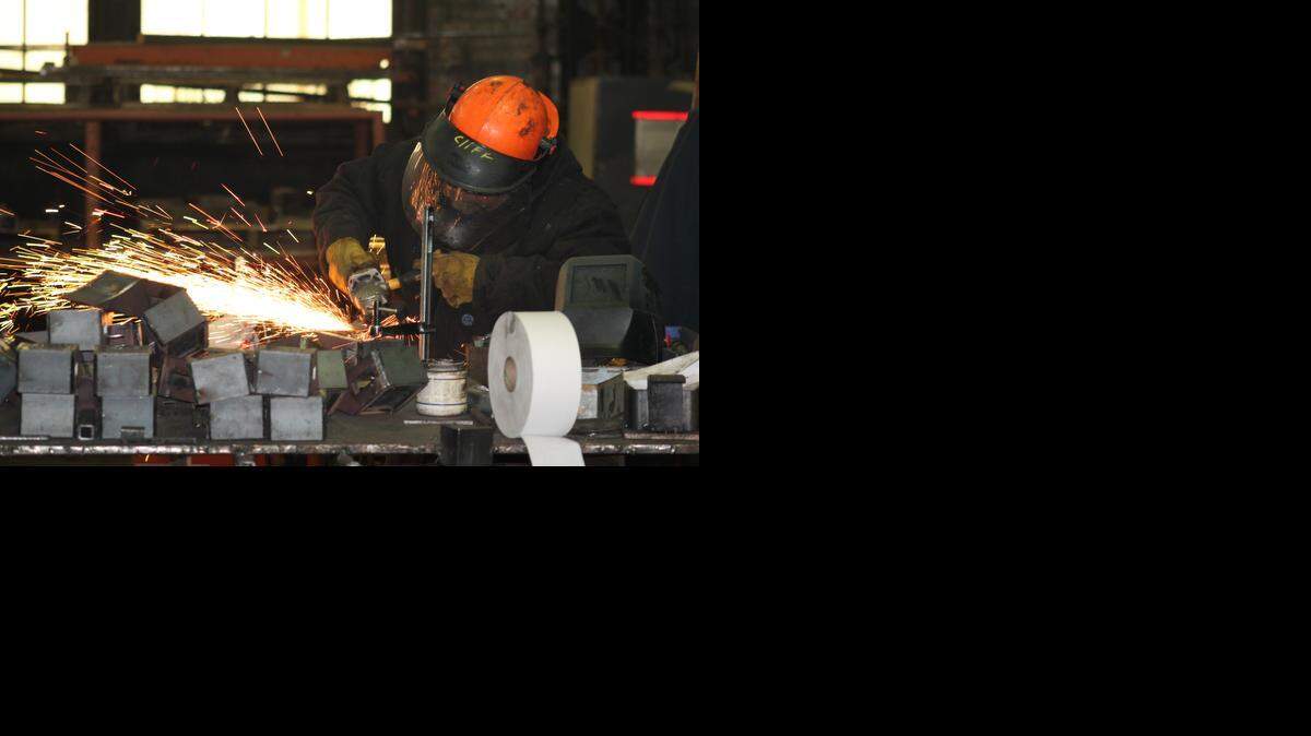
Clifford Gehring grinds metal parts at TM Track Machines in Parsons.
