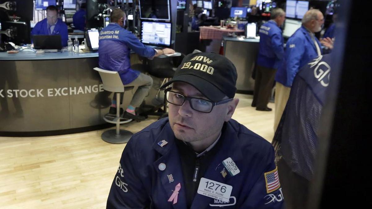 Specialist Mario Picone wears a “Dow 19,000” hat as he works on the floor of the New York Stock Exchange on Tuesday. U.S. stocks rose Tuesday morning after most major indexes closed at record highs the day before, and the Dow closed at 19,023.87.