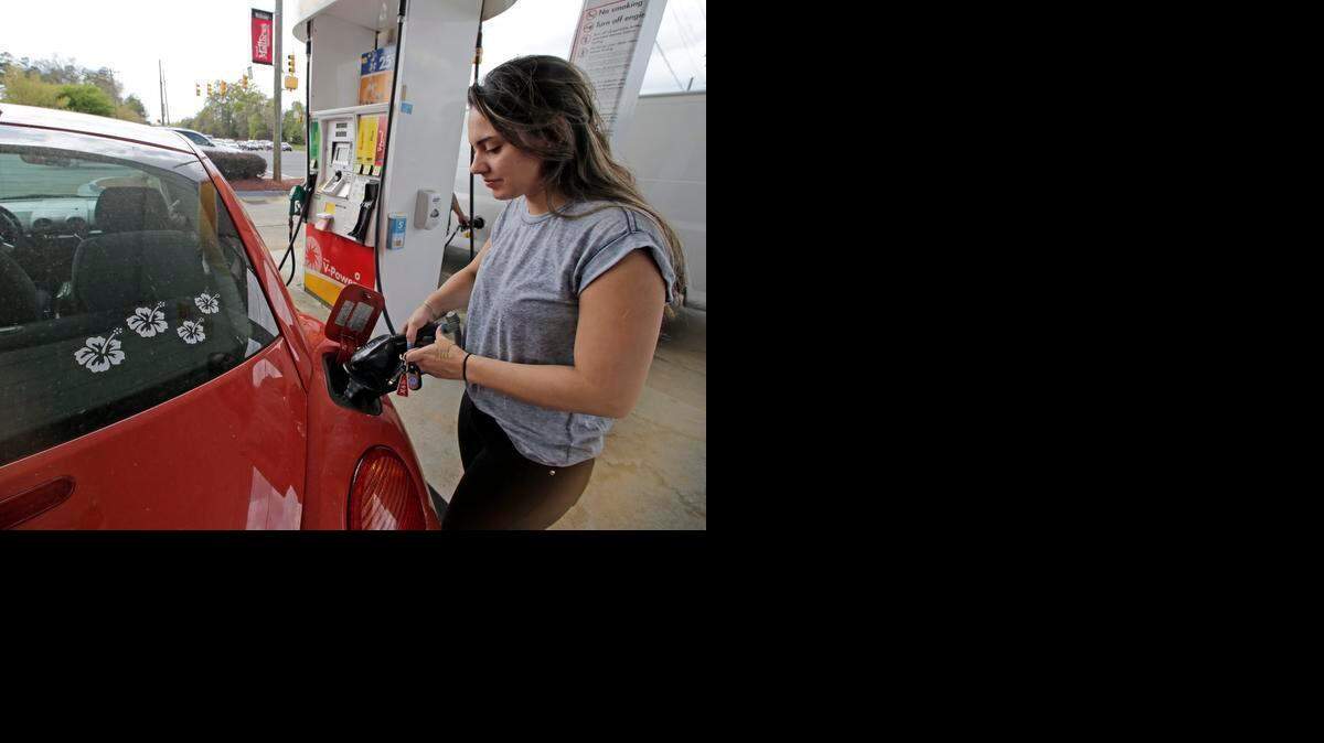 
Lucy Perez, of Charlotte, N.C., pumps gas at a station in Matthews, N.C., on Monday. Drivers will see the lowest summer gasoline prices in about six years, according to an Energy Department report released Tuesday. 

