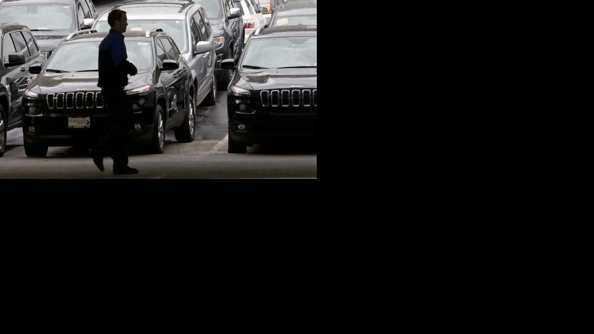 
A worker on a Chrysler car lot passes lines of mostly Jeep SUVs Tuesday in San Diego. Black Friday promotions — coupled with falling gas prices, low-interest loans and hot new vehicles — drove U.S. auto sales higher in November, kicking off what's expected to be a strong holiday season. Chrysler, which sells Jeep cars, posted its best November in 13 years. 
